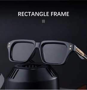 Detailed view of rectangle black frames with gold rivet accents and metal temple hinges