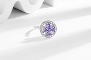 Detailed macro view of rotating four-leaf clover ring with purple heart-shaped zircons