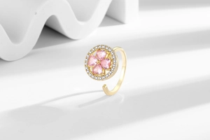 Detail of adjustable gold ring with pink heart-shaped clover and cubic zirconia