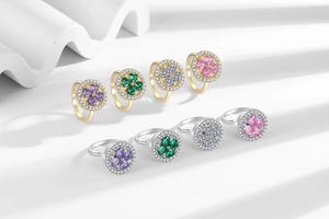 Close-up of four-leaf clover rings with colorful heart-cut stones and crystal halo