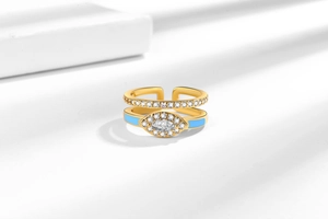 Close-up of gold double-layer evil eye ring with blue enamel and sparkling zircon accents