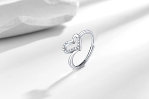 Detailed close-up of an open heart ring with sparkling cubic zirconia on white background