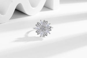Macro detail of rotating silver floral ring with cubic zirconia petals and shimmering crystals