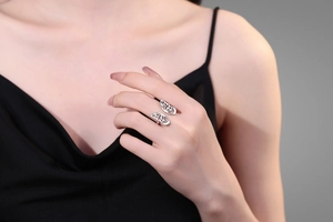 Detail of elegant hollow butterfly ring on finger with polished silver-tone finish
