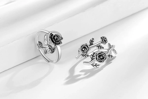 Detailed view of vintage silver rose vine rings with oxidized black finish on white steps