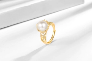 Close-up of vintage hollow-out gold floral ring with a large lustrous white pearl