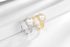 Detailed view of gold and silver filigree rings with large white round pearls