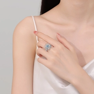 Rotating blue evil eye ring with silver petals shown on model in white dress