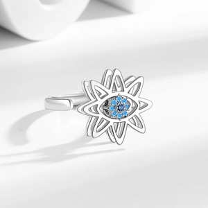Rotating Evil Eye star ring in silver finish with blue crystals on minimalist pedestal