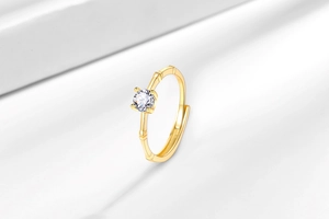 Detail of a golden bamboo style adjustable ring with a brilliant round cut moissanite
