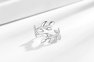 Detailed view of silver olive leaf open ring with polished metallic mirror finish