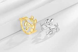 Close-up of olive leaf rings in gold and silver finish with adjustable open design