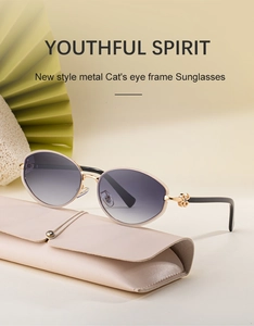 Detail of cat-eye sunglasses with gold metal frames and floral temple decorations