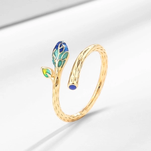Adjustable gold ring with leaf design featuring green gradient enamel on a gray background