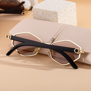 Detailed close-up of geometric gold metal frame sunglasses with gradient brown lenses