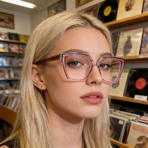 Cat-eye blue light glasses with pink brown gradient frame worn by a model in a studio