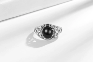 Detail view of oval black agate ring with vintage silver filigree and ornate scrollwork