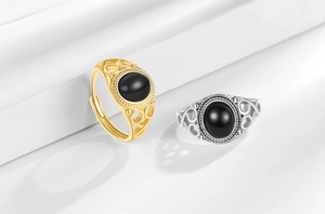 Detail of vintage oval black agate rings with ornate spiral filigree in gold and silver