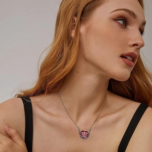 Close-up of red heart pendant with silver ribcage skeleton design on a female neck