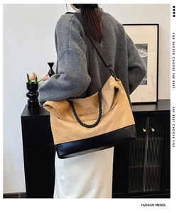 Detail of a large color-block tote bag with a camel suede finish and wide strap
