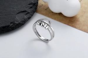 Detail of adjustable silver ring featuring rotating beads and micro-set cubic zirconia