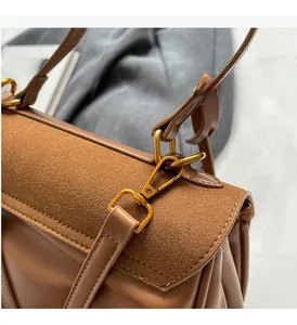 Détail du sac à main en cuir camel avec texture en daim et boucles dorées vintage