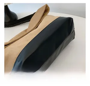 Close-up of dual-texture tote bag featuring khaki suede and black smooth leather stitching