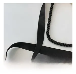 Detailed macro view of black textured nylon shoulder straps and woven rope for bags