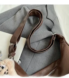 Close-up of brown PU leather tote bag with silver hardware and a white plush cat charm