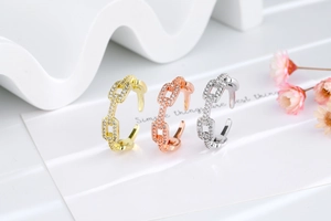 Detailed view of adjustable chain-link rings in gold, rose gold, and silver with zircon