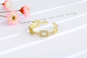 Detailed close-up of golden adjustable chain link ring with sparkling zircon stones