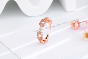 Close-up of rose gold chain-link open ring with shimmering pavé zircon stones