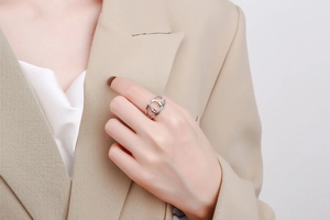 Detail of silver spinning ring with pavé crystals on a model wearing a blazer