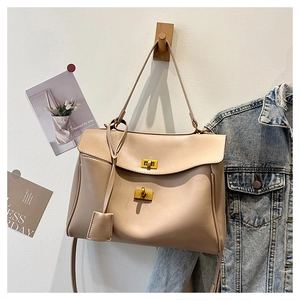 Detail of apricot leather handbag featuring dual gold twist locks and long handles