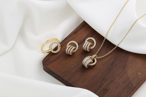 Close-up of golden jewelry set with necklaces and rings on dark wooden cubes