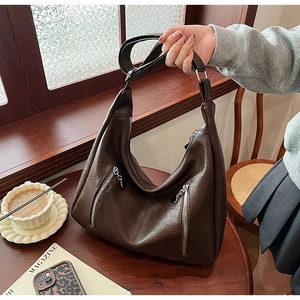 Detail of vintage dark brown PU leather hobo bag with dual vertical zippers and wide strap