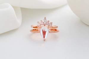 Macro detail of rose gold crown ring set featuring teardrop moonstone and marquise stones