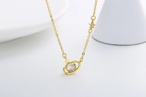 Detail of gold planet necklace featuring a sparkling zircon stone and star charms