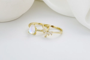 Detail of gold double-layer crown heart ring set with teardrop opal and zircons