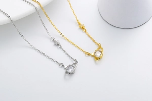 Detailed view of silver and gold planet necklaces with sparkling cubic zirconia stars