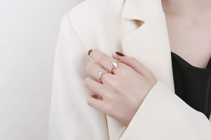 Close-up of rose gold crown ring set with a pear-shaped moonstone on a hand