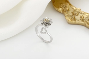 Detail of sunflower spinner ring with gold core petals and open heart design on silver band