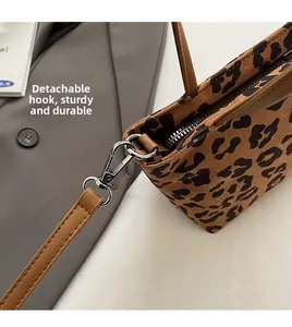 Détail du sac seau à imprimé léopard avec bandoulière amovible marron et boucles argentées