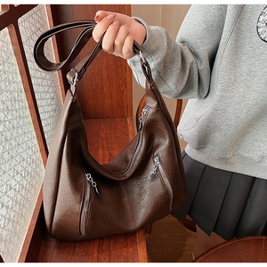 Detail of dark brown faux leather hobo bag with zip pockets for commute and daily use