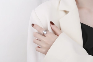 Close-up of a silver crown ring with a pear-cut light blue stone and zircon details