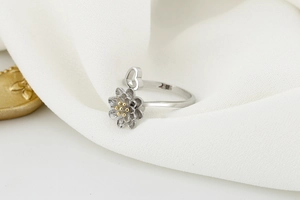 Detail shot of a silver sunflower spinning ring with a golden heart accent and petals