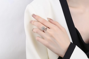 Detailed close-up of rotating sunflower and hollow heart ring on woman's finger