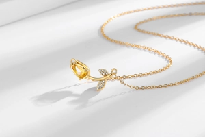 Detailed view of tulip pendant necklace with yellow crystal and sparkling stone leaves