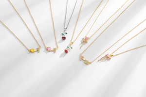 Detailed flat lay of seven gold and silver floral necklaces with rose and tulip pendants