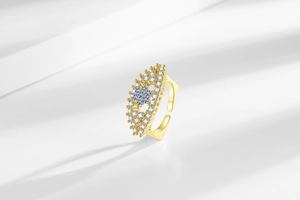 Macro detail of gold-plated evil eye ring with blue and white zircon micro-pave